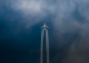 Airplane soaring through the sky leaving a trail