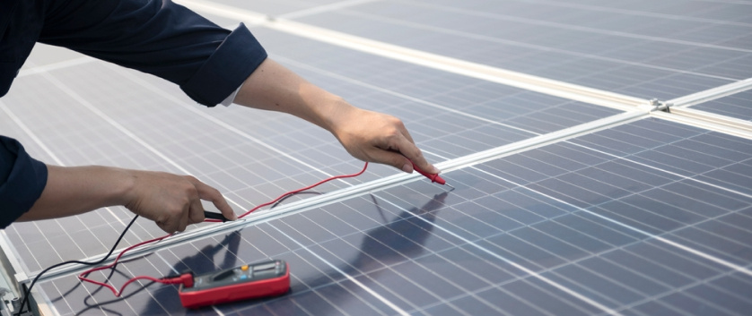 Technician working on solar panels, showcasing consulting for operational efficiency, asset optimization, and energy sustainability.