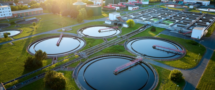 Circular reservoirs in a water treatment facility symbolizing comprehensive engineering and lifecycle management solutions.