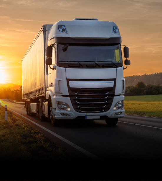 A sleek white commercial truck driving on a highway at sunset, representing efficient and robust logistics solutions.