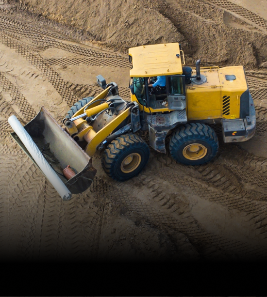 A powerful yellow front loader in action at a construction site, showcasing advanced machinery for heavy-duty operations.