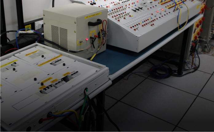 Features power testing devices and engineers, representing advanced research in automotive electronics.