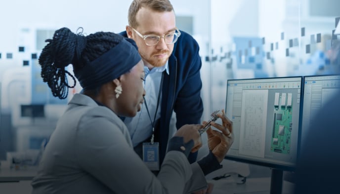 A  team of professionals analyzing semiconductor designs on a computer